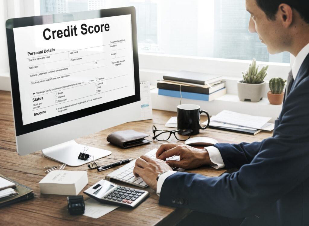 Business owner analyzing financial documents to protect business credit score during debt restructuring.